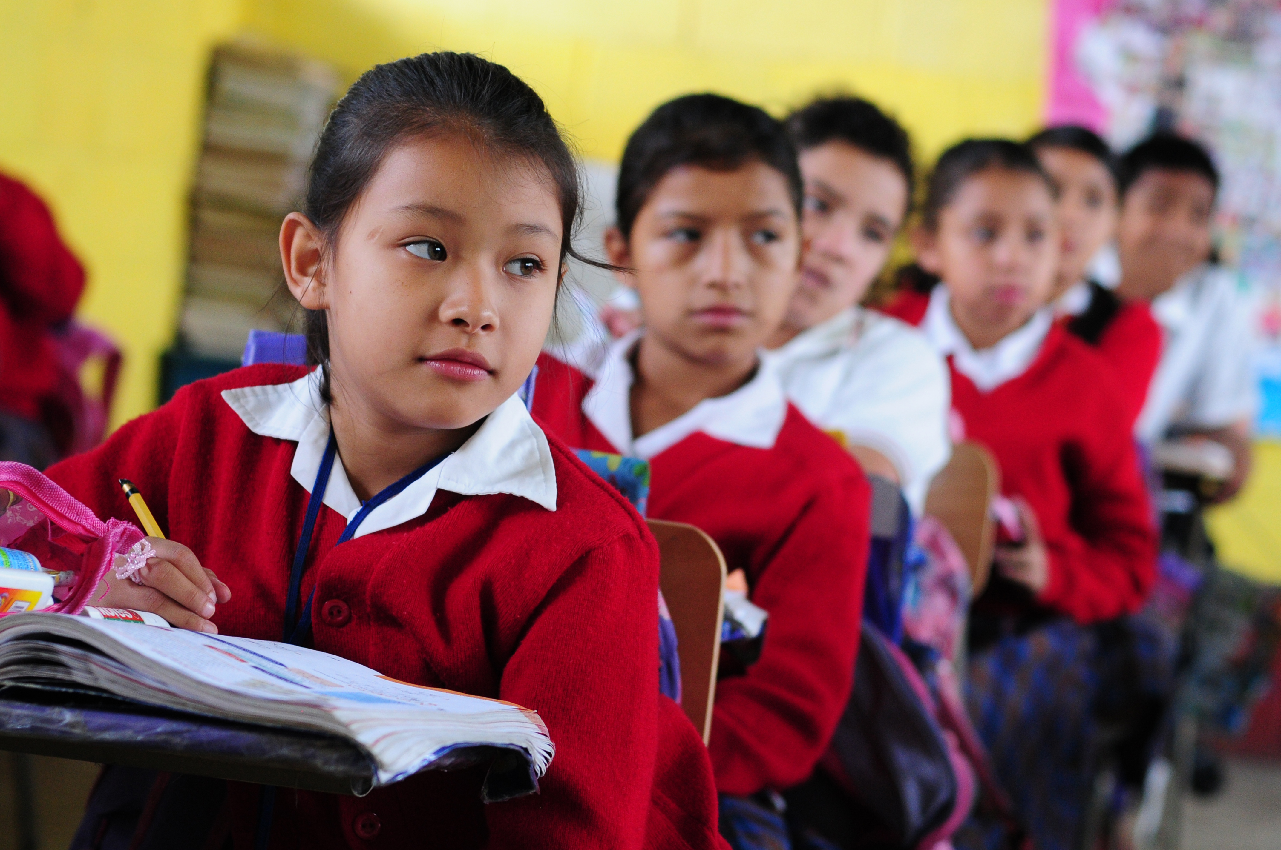 Children listen to their teacher in their classroom in El Renacimiento school, in Villa Nueva, Guatemala. Credit: Photo: Maria Fleischmann/World Bank